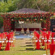 Decorative setup with floral arch and chairs in a garden - Moments Rentals