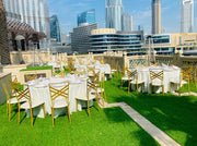 Outdoor dining setup with tables and chairs on a rooftop with city skyline in the background - moments rentals