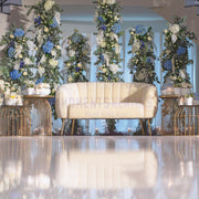 Decorative setup with floral arrangements and a beige sofa in a room.