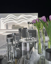 Dining table setting with tulips and a modern headboard in the background