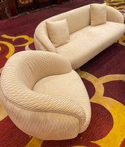 Beige textured sofa and armchair on a red and gold patterned carpet