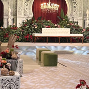 Decorative indoor setting with a Beige Velvet Sofa, green ottomans, and floral arrangements in a formal Garden Setting.