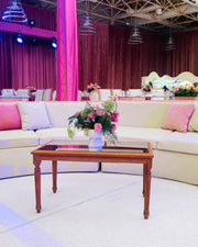 Decorated indoor setting with a floral arrangement on a coffee table, pink and white decor elements.