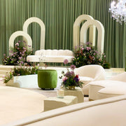 Modern Bridal Set up with white furniture, green plants, and a chandelier.