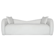 A modern Beige upholstered sofa with rounded arms, a low curved backrest, and two matching white throw pillows, shown against a plain white background.