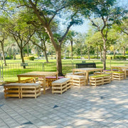 Outdoor seating area with wooden tables and benches in a park setting