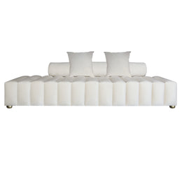A modern beige velvet tufted bridal sofa with a segmented, channel-tufted front, two cylindrical back cushions, and two square throw pillows, shown on a plain white background.
