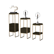 Set of three small tables with gold frames and black surfaces, each topped with a decorative lamp.