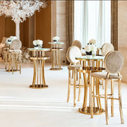 Decorative indoor setting with gold tables and chairs, white flowers, and elegant decor.