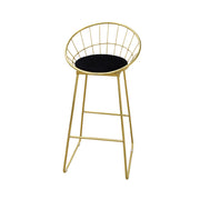Gold metal bar stool with black cushion on a white background
