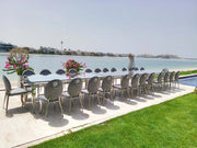 Outdoor dining setup with chairs and table by a waterfront.
