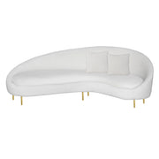 A modern curved white velvet sofa with two square white throw pillows and slim gold metal legs, shown against a plain white background.