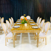 Dining table set with plates and a floral centerpiece against a black curtain backdrop