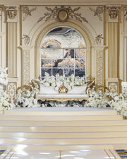 Decorative interior with ornate wall molding, a floral arrangement, and a large mirror.