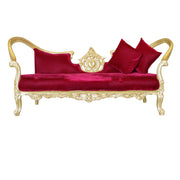 Red velvet sofa with gold frame and red cushions on a white background