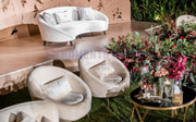 Modern outdoor furniture set with Beige Velvet Sofas and a table, surrounded by flowers and decorative items.