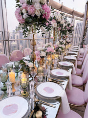 Elegant dining table setup with floral arrangements and candlelight in a high-rise setting.