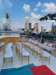 Outdoor seating area with chairs and tables on a rooftop with city skyline in the background - Moments Rentals