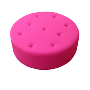 Round pink cushion with button tufting on a white background