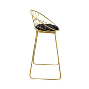 Gold metal bar stool with black cushion on a white background