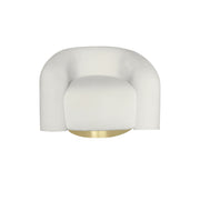 A modern beige velvet upholstered accent chair with a curved back and seat, featuring a polished gold circular base.