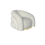 A modern curved armchair upholstered in beige velvet fabric with a gold circular base.