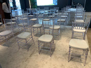 Clear chairs with beige cushions arranged in a room with a neutral color - moments rentals 