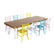 Wooden dining table with colourful children's chairs on a white background