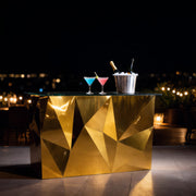 Gold geometric table with drinks on a dark outdoor setting