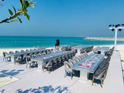 Moments Rentals Outdoor dining setup with tables and chairs by the beach