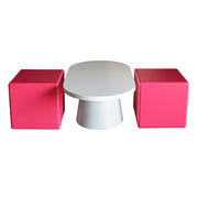 White table with two pink cube-shaped stools on a white background