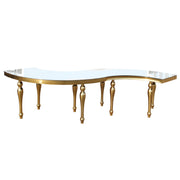 Round S shaped Dinning table with gold legs and a clear glass top on a white background