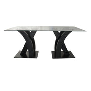 Modern dining table with black metal legs and glass top on a white background - Moments rentals