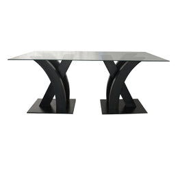 Modern dining table with black metal legs and glass top on a white background - Moments rentals